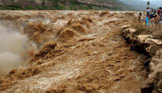 Tourists watch Hukou Waterfall of Yellow River in N China